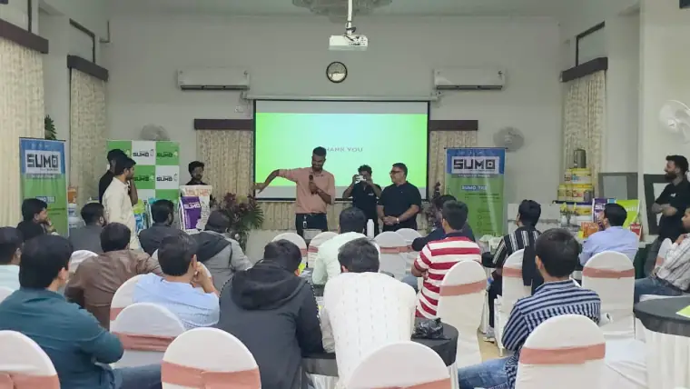 Presenter addressing a full room of dealers at a SUMO dealer meet, India